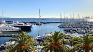 A marina with multiple boats docked, palm trees in the foreground, and a clear sky. - Studio with terrace for 2 people in Giens – Secure residence near the beaches (HYERES)
