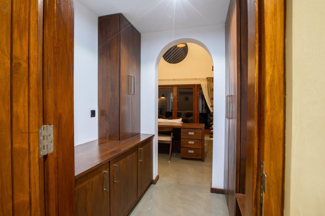A hallway with wooden cabinets and a desk area.