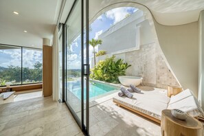 Et moderne spa-rum med en glasomkranset uendelig pool, et stort badekar og en solstol.
