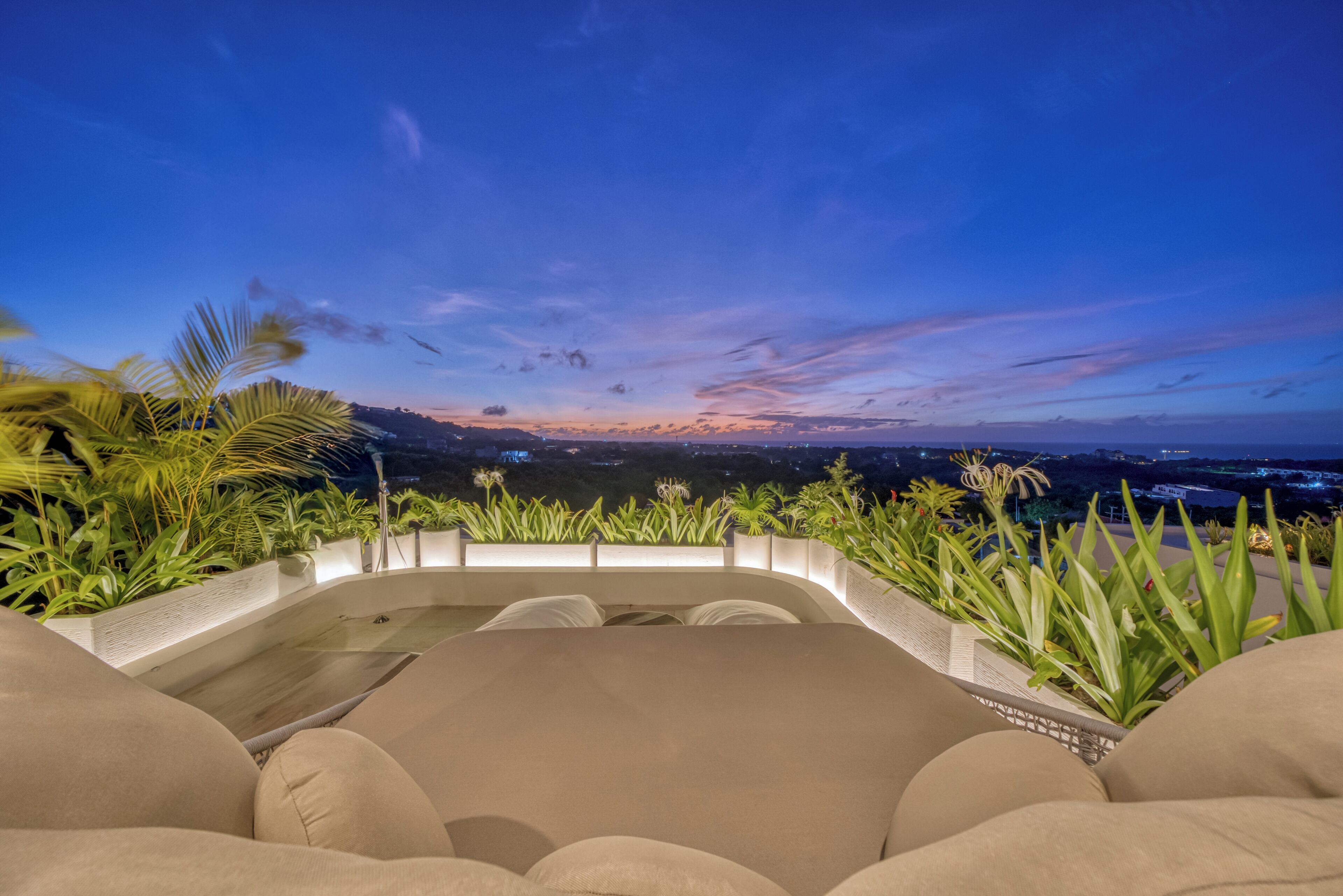 A modern outdoor seating area with a view of the cityscape at dusk.