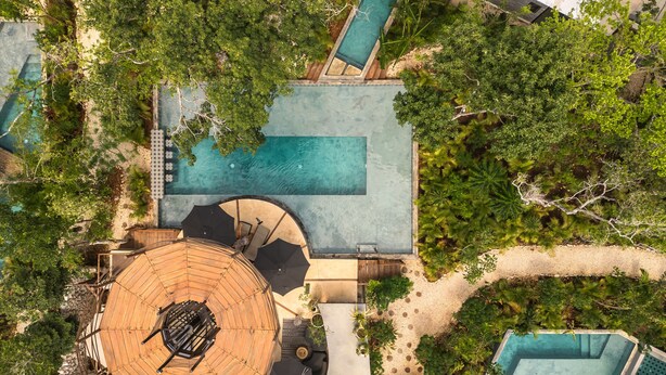 An aerial view of a resort with a swimming pool, a covered seating area, and lush greenery. - Siwa Jungle-Luxury 2BR Retreat with Private Rooftop, Deep Pool & BBQ (Tulum)