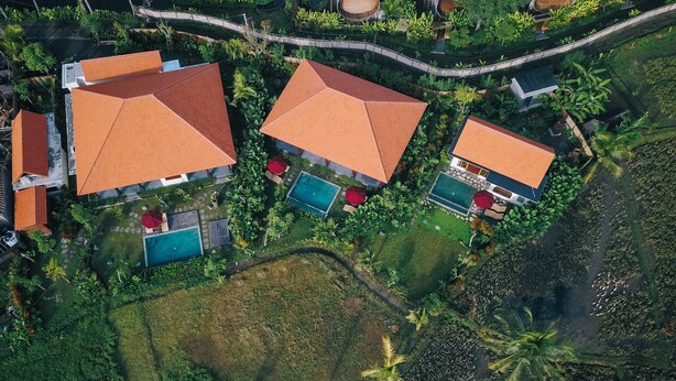An aerial view of a resort with multiple buildings, swimming pools, and lush greenery. - DENAYA UBUD VILLA (Ubud)