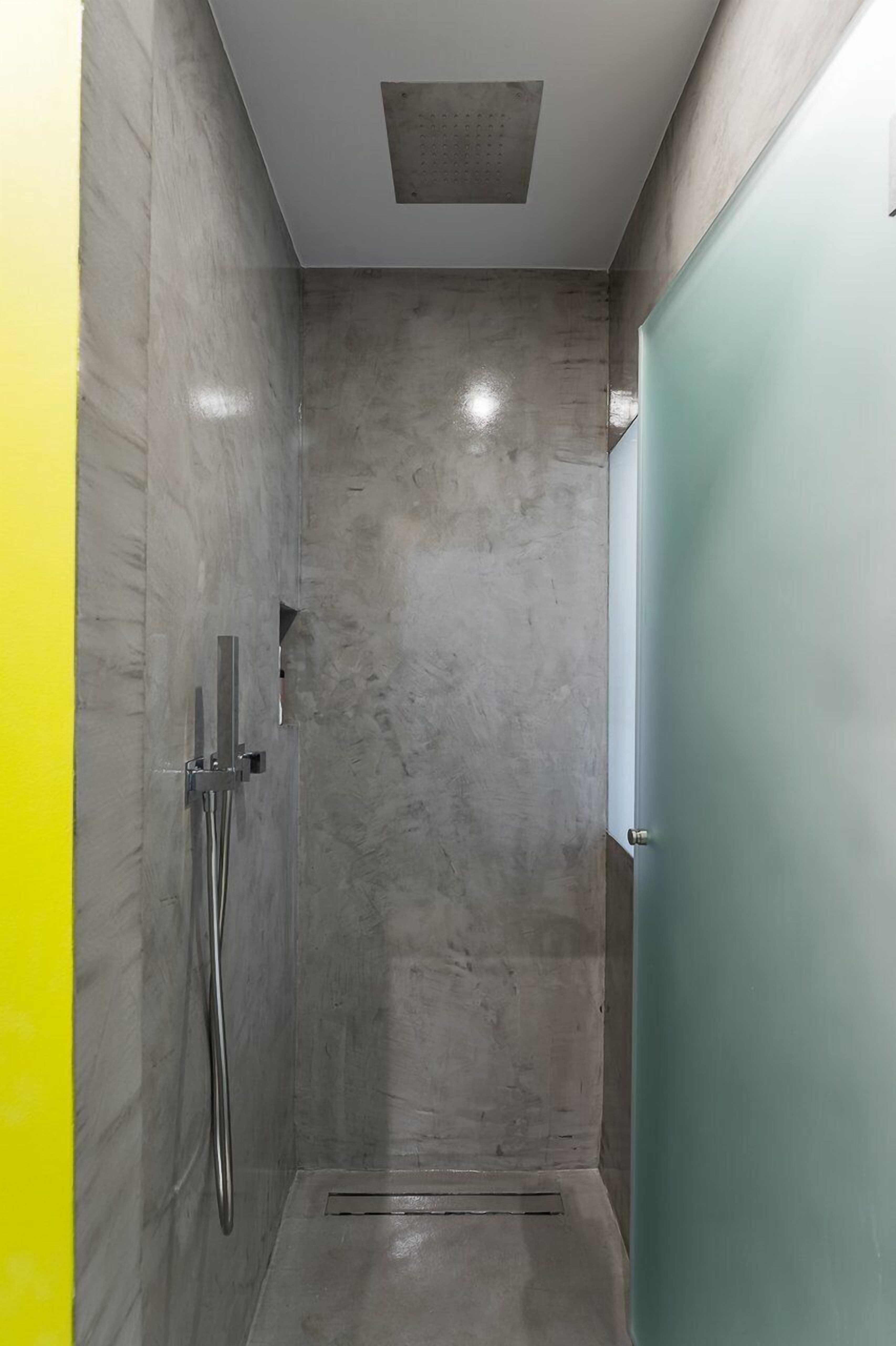 A small, enclosed shower area with a tiled wall and a door.