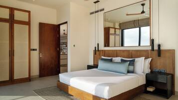 A bedroom with a large bed, wooden headboard, bedside tables, a mirror, and a ceiling fan.