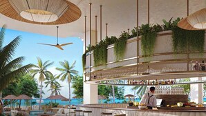 A bar area with a view of the ocean, bar stools, and a bartender. - Southbeach Weligama (Weligama)