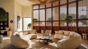 A spacious living area with a large window, a round coffee table, and modern furniture. - Southbeach Weligama (Weligama)