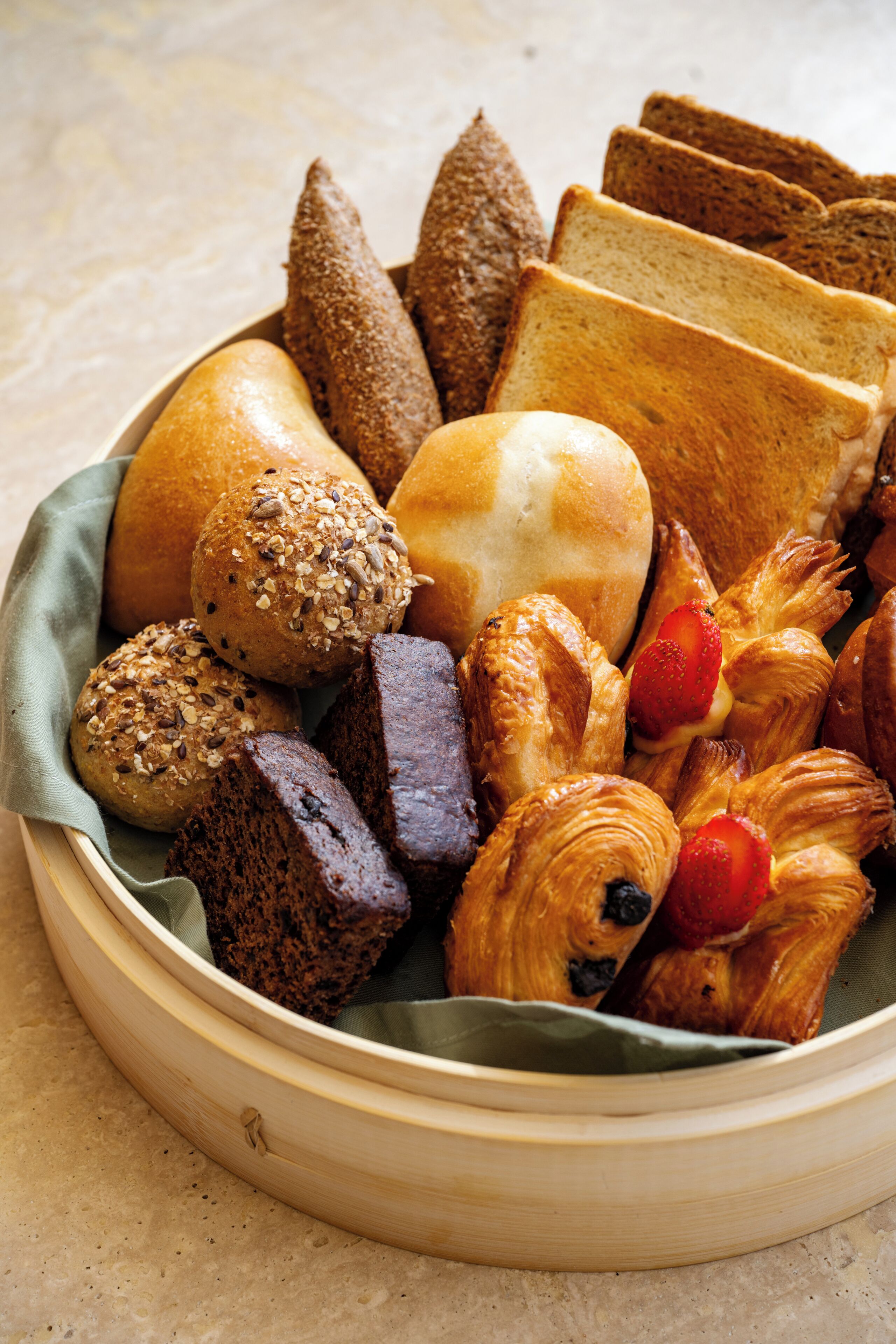 A variety of breads and pastries in a basket.