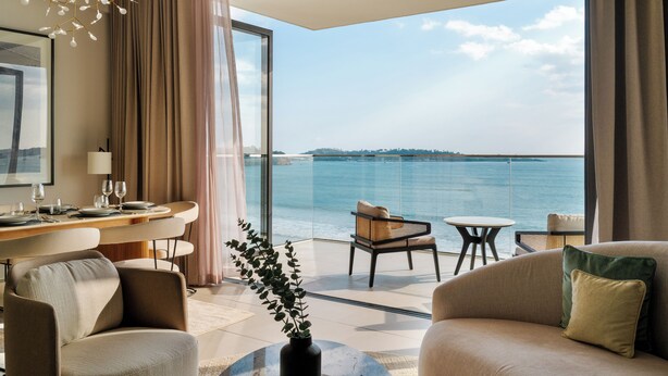 A modern hotel room with a balcony, a dining area, and a seating area with a view of the sea. - Southbeach Weligama (Weligama)