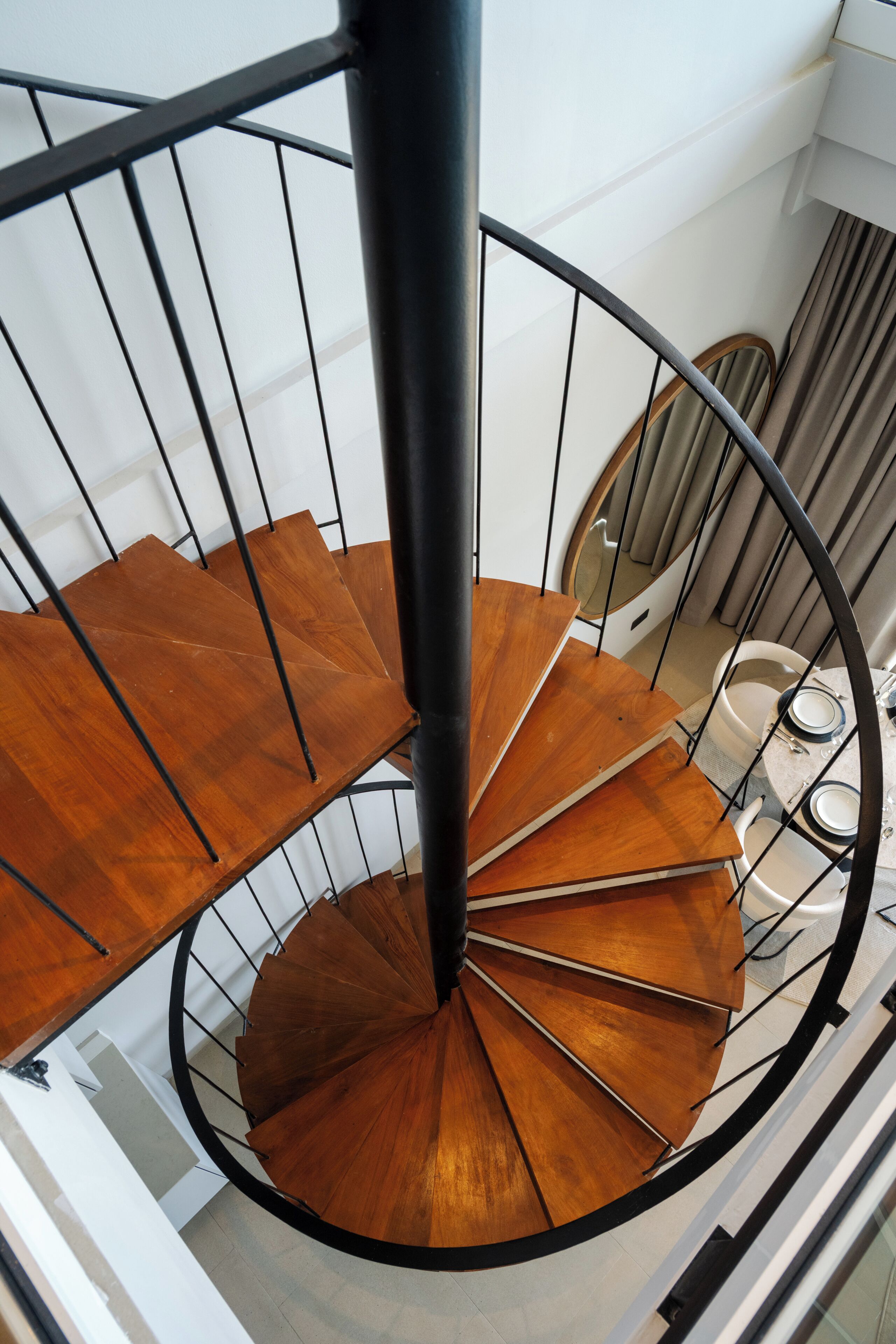 A spiral staircase with wooden steps and black metal railings.