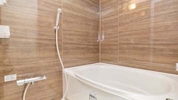 Bañera con ducha, secador de pelo, toallas, shampoo