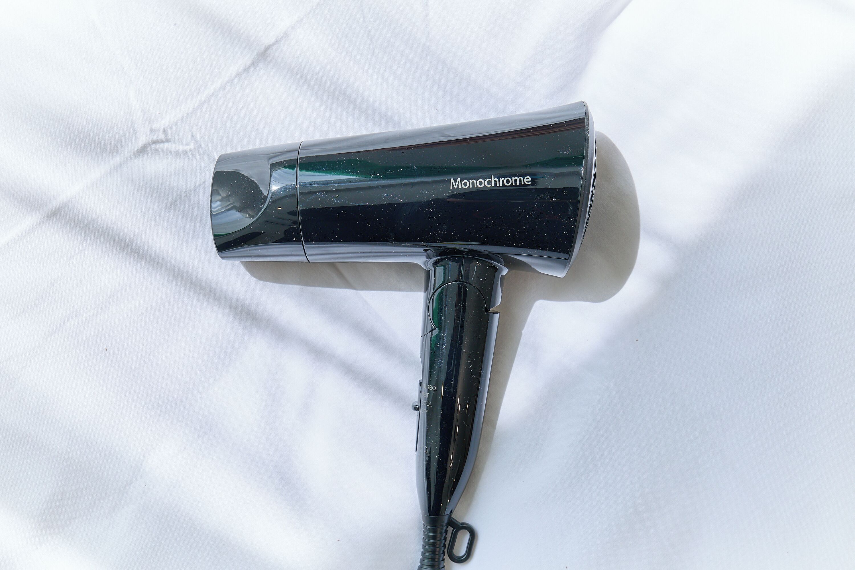 A hairdryer with the label 'Monochrome' on a white surface.