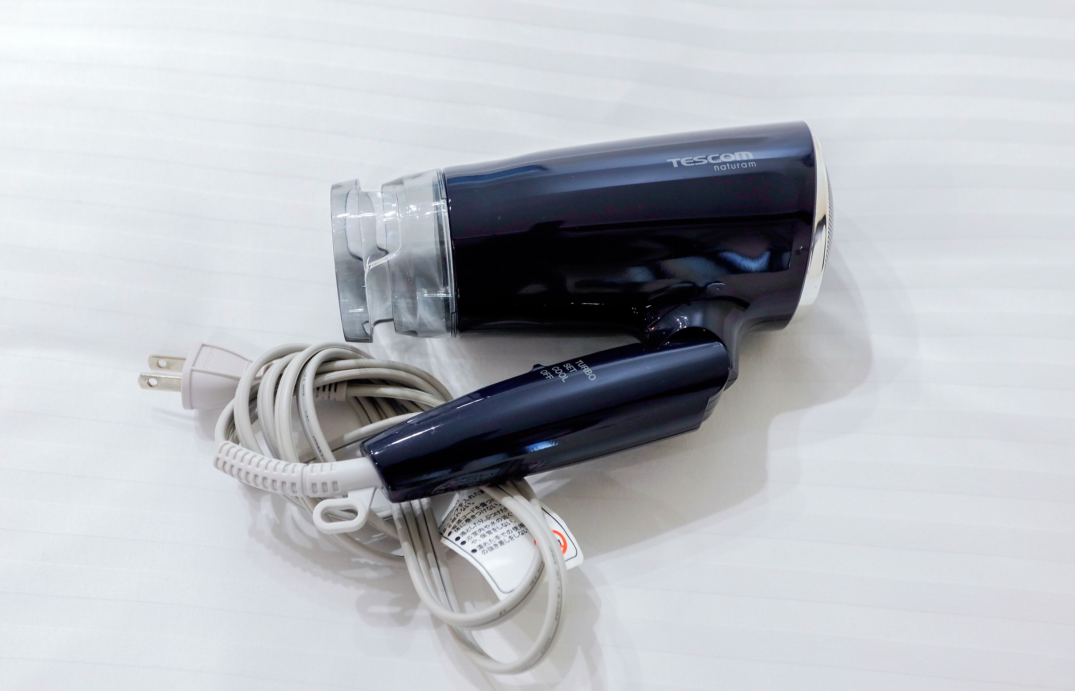 Une brosse à dents électrique noire et blanche, livrée avec un câble de chargement.