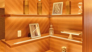 Un mostrador de recepción de madera con un cuadro enmarcado, un florero pequeño y un candelabro.