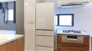 Una cocina moderna con un refrigerador blanco, lavavajillas integrado y estufa a gas.