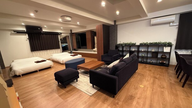 Una sala de estar moderna con un sofá, un reposapiés y una mesa de centro.
