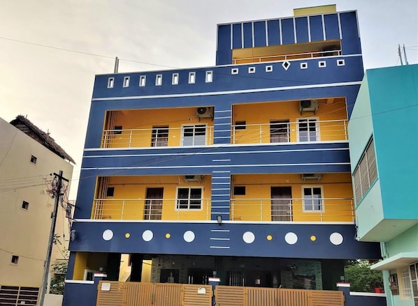 A multi-story building with balconies, windows, and a flat roof.