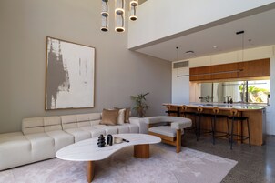 A modern living room with a sofa, coffee table, and a large abstract painting.