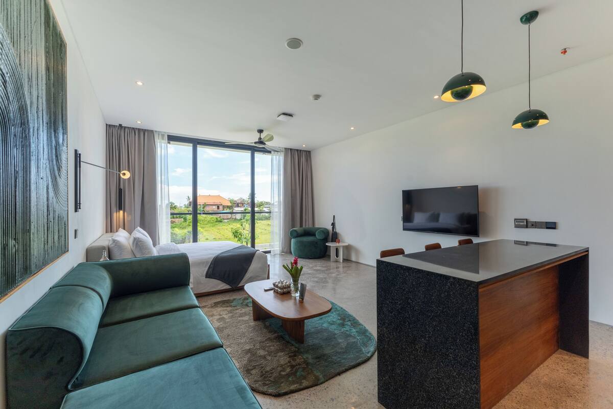 Une chambre d’hôtel moderne dotée d’un grand lit, d’un canapé, d’un coin repas et d’une télévision.