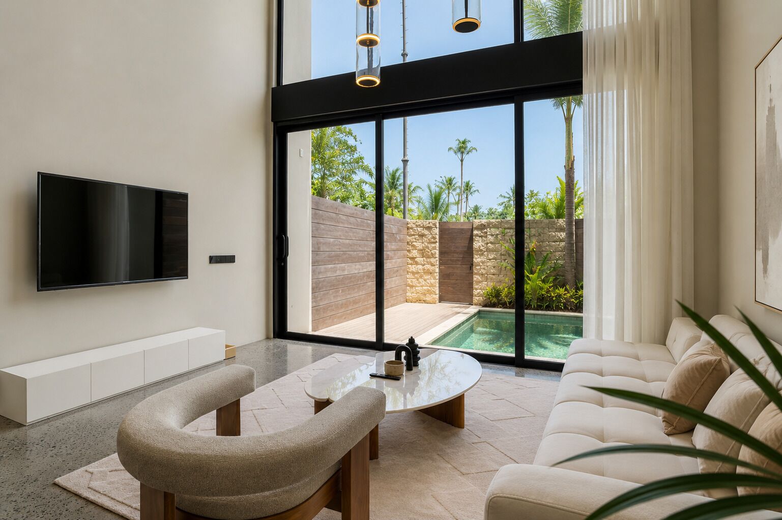 A modern living room with a flat-screen TV, a round coffee table, and a sofa.