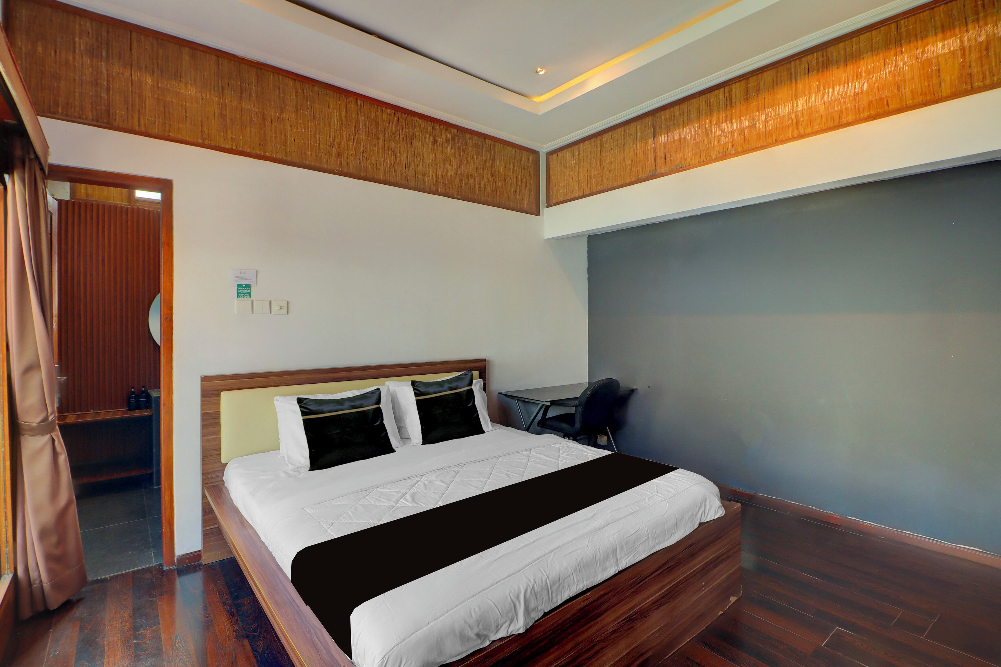 Una habitación de hotel con una cama, un escritorio y una silla.