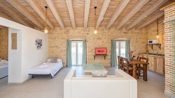 Una habitación acogedora con cama, sofá, mesa de comedor y zona de cocina.