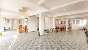 A spacious lobby with a reception desk, a chandelier, and a kitchen area in the background. - Treebo Lime Light (Pune)