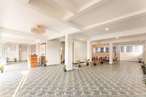 Eine großzügige Lobby mit einer Rezeption, einer Kristallleuchter und einem Küchenbereich im Hintergrund.