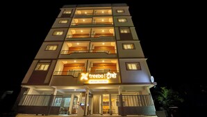 A multi-story hotel with balconies, a sign in a foreign language, and a gated entrance. - Treebo Lime Light (Pune)