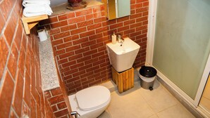 Une salle de bain avec des toilettes, un lavabo et un miroir au-dessus du lavabo.