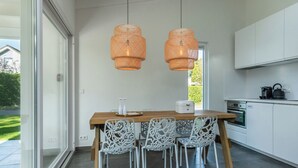 Eine moderne Küche mit einer Holzinsel, weißen Stühlen und einem eingebauten Backofen.