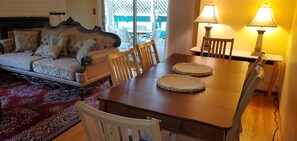 Un comedor con una mesa de madera, sillas y dos individuales tejidos.