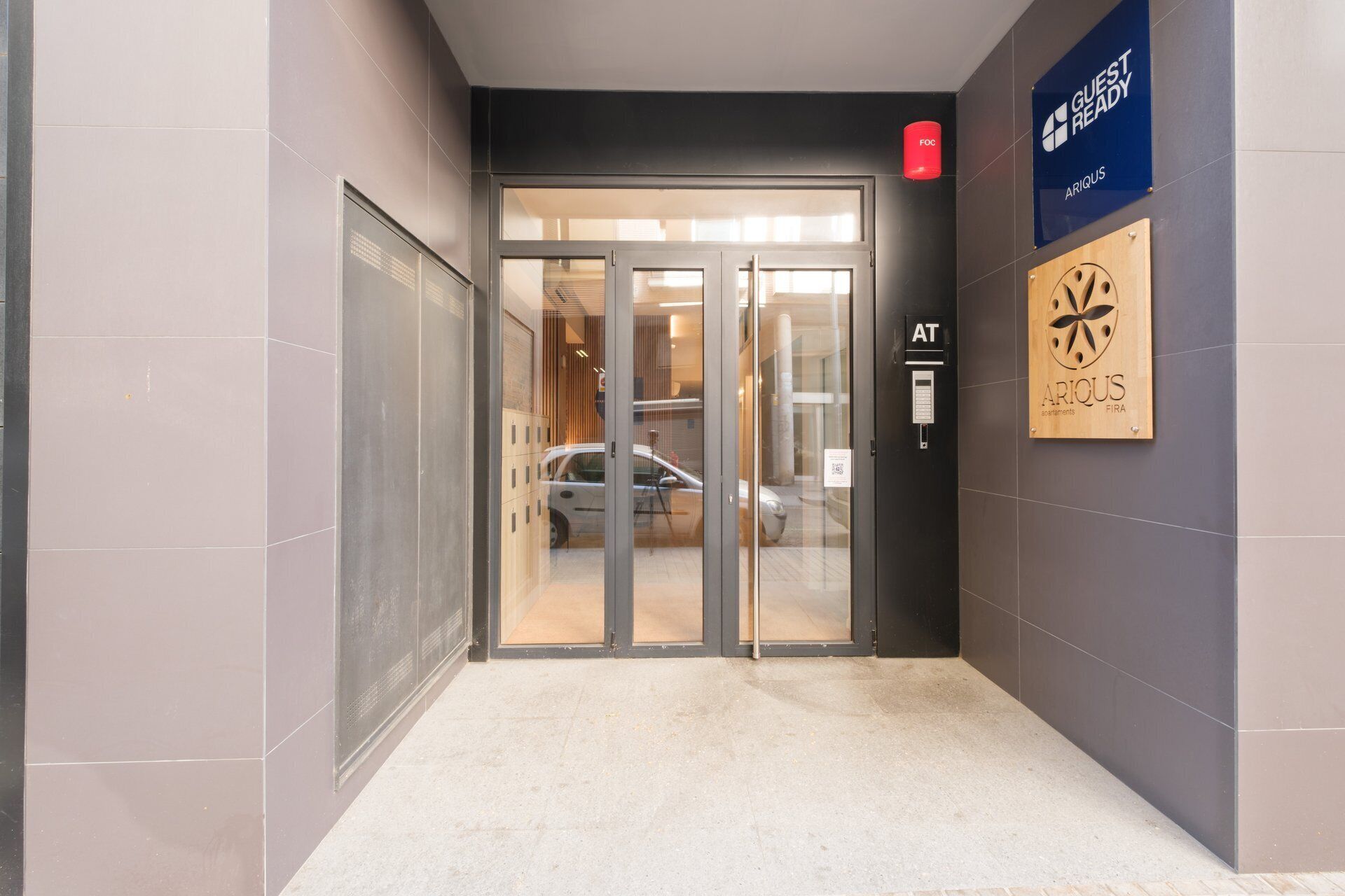 A hotel entrance with a glass door, a reception desk, and a sign indicating guest readiness.