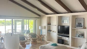 Un salon spacieux avec un plafond haut, un téléviseur intégré et des sièges confortables.