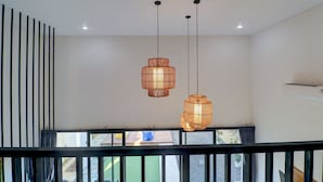 A modern interior with a staircase, two hanging wicker lamps, and a view through the windows. - Collection O near Sanur Beach formerly  (Denpasar)