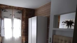 Una camera da letto con un letto, un armadio e una porta che dà su un'altra stanza.