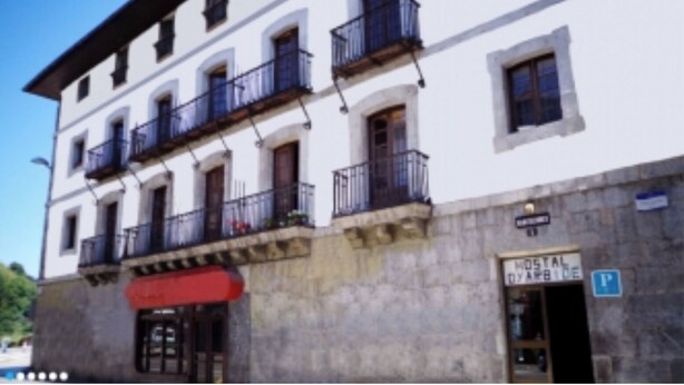 Un edificio con un cartello che indica 'HOTEL DE ARBIDE' e un segnale di parcheggio.