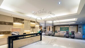 A modern hotel lobby with a reception desk, seating area, and artwork on the walls. - High Floor Manila Bay View, Near MOA & Airport (Pasay City)