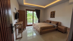 A bedroom with a bed, a desk, a TV, and a balcony. - Collection O near Sanur Beach formerly (Denpasar)