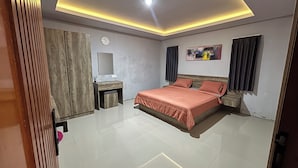 A modern bedroom with a bed, bedside tables, a mirror, and a painting on the wall. - Collection O near Sanur Beach formerly (Denpasar)