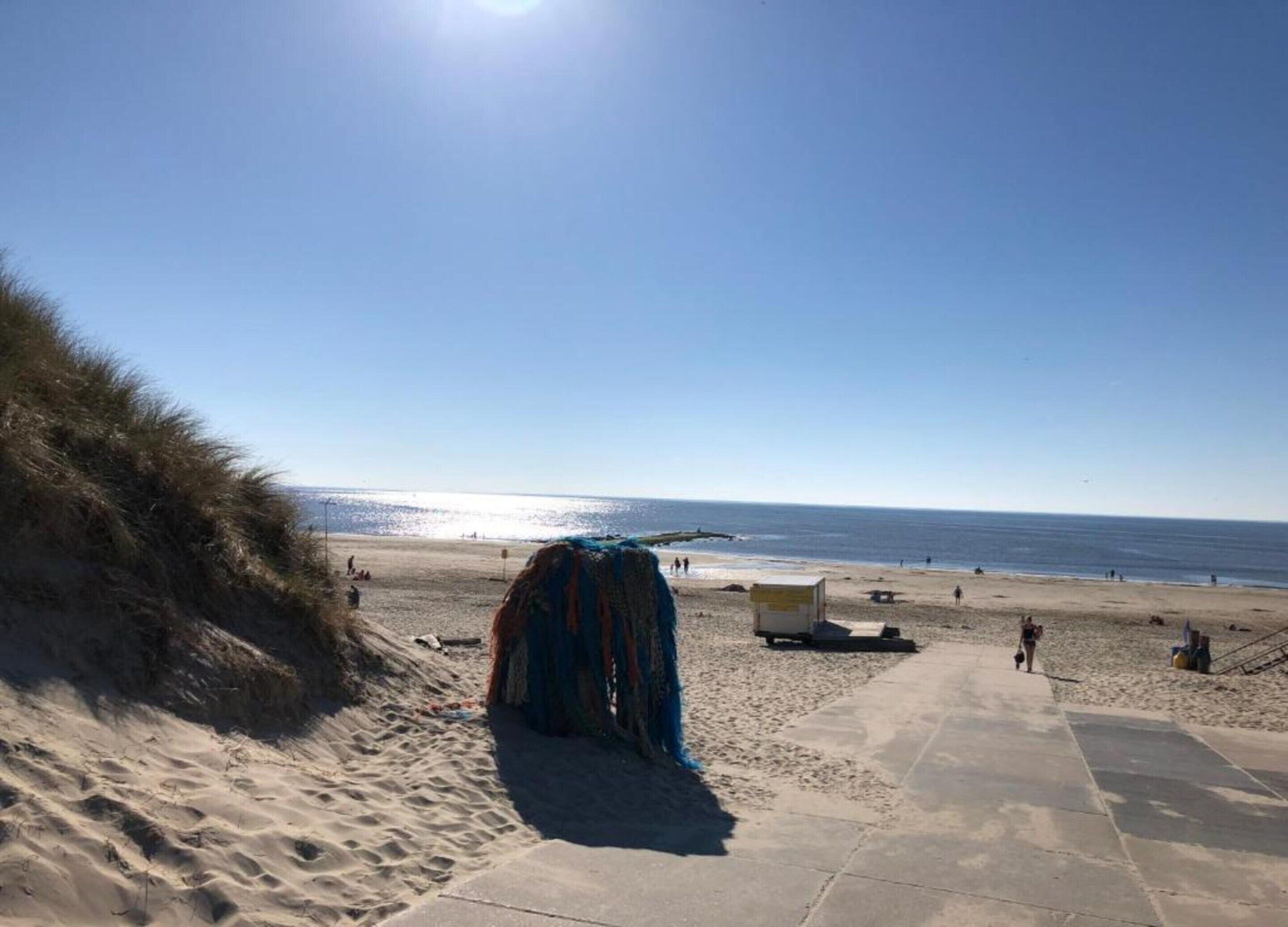 A beach with a clear sky, sandy area, and a few people.