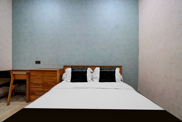 Une chambre à coucher avec un lit, un bureau en bois et une chaise.