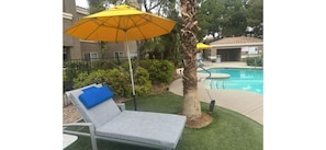 A poolside area with a lounge chair, a yellow umbrella, and a palm tree. - Fabulous Las Vegas Corporate 3bed LuxuryStrip Supercondo +gym Jacuzzi,Pools (Las Vegas)