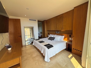 A bedroom with a large bed, wooden wardrobe, and a small desk with a plant. - Charming 2-bedroom apartment with AC in awesome ZanTamaR (Cruz de Huanacaxtle)