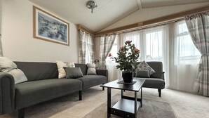 Een woonkamer met een bank, een salontafel en een potplant.