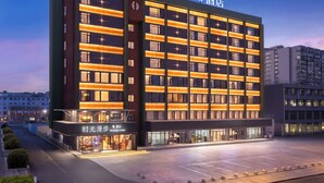 A modern hotel building with multiple floors, large windows, and a well-lit facade. - Nostalgia Hotel Hangzhou Wulinmen Branch (Hangzhou)