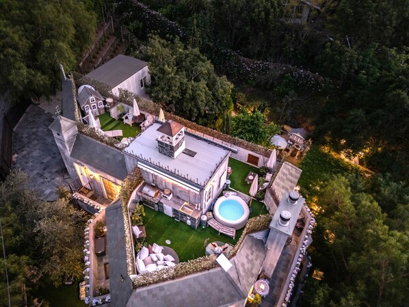 Vista aérea de una extensa propiedad con varias construcciones, una piscina y un jardín cuidado.