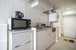 Kylskåp, mikrovågsugn, spishäll och grytor/köksredskap