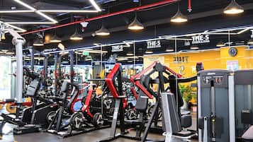 Ein Fitnessstudio mit verschiedenen Trainingsgeräten, darunter Kraftmaschinen und Kurzhanteln.