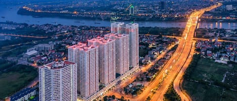 A high-rise building complex with multiple floors, surrounded by roads and a river.