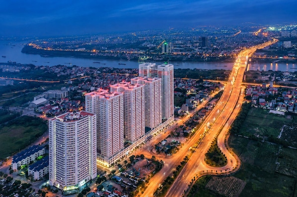 A high-rise building complex with multiple floors, surrounded by roads and a river.